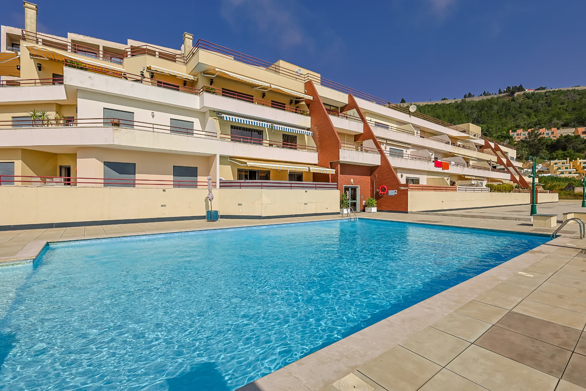 Casa branca tradicional em Sesimbra com vista para o Atlântico ao pôr do sol